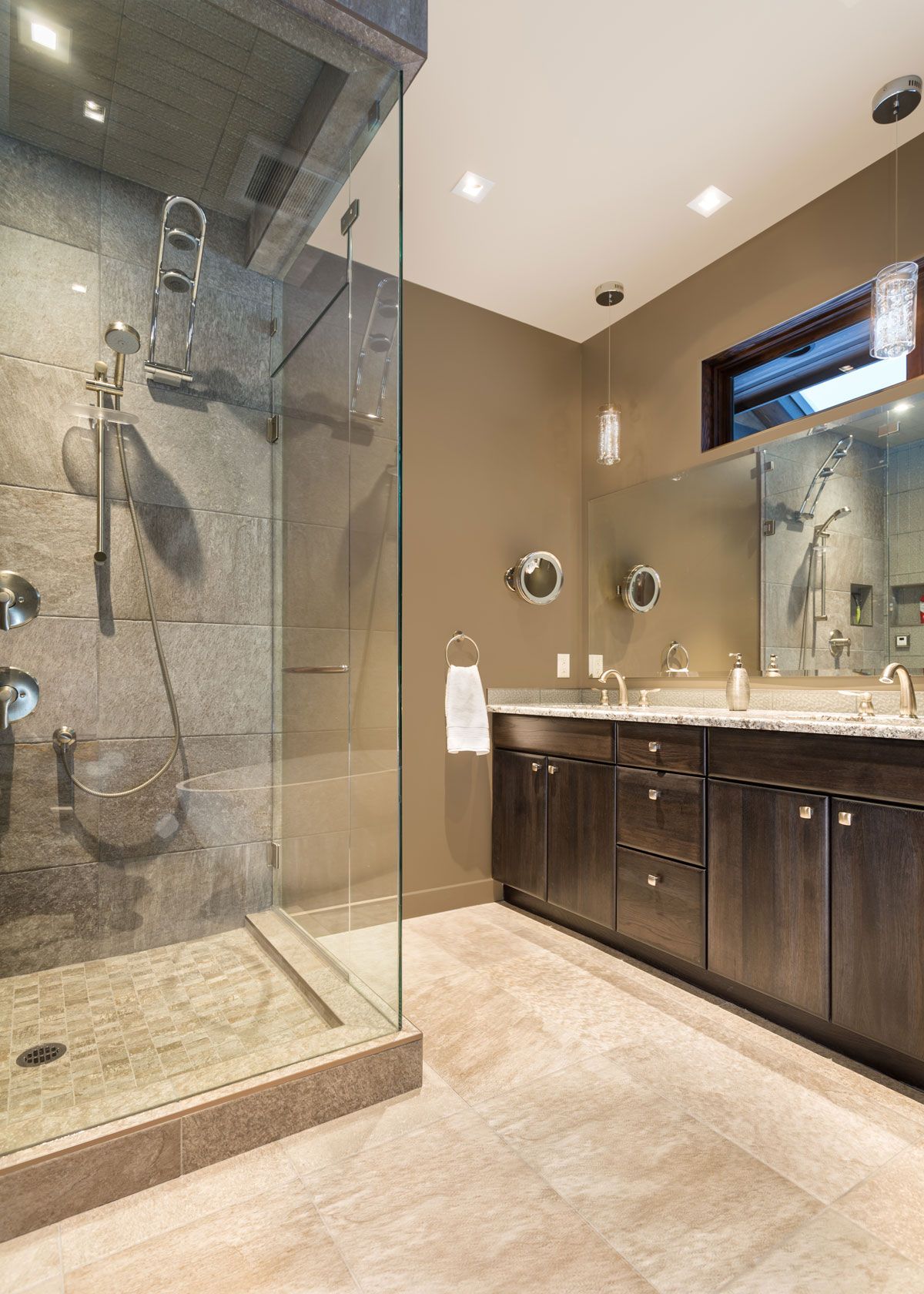 A bathroom with a stone vanity and glass shower