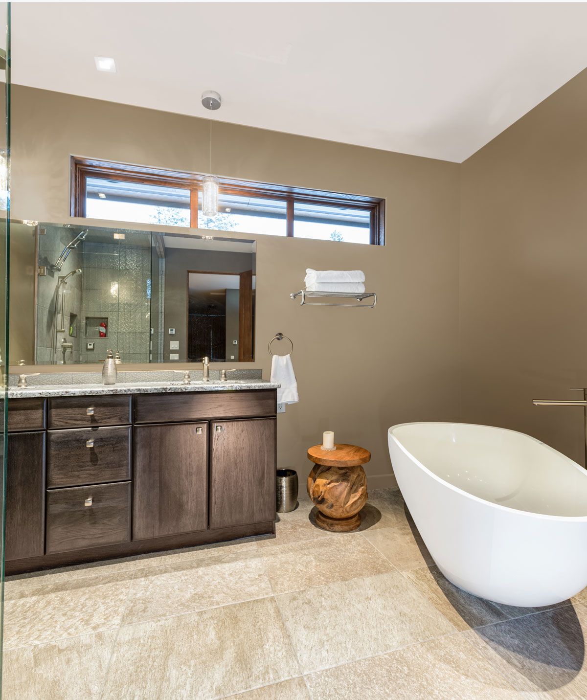 A bathroom with a stone vanity and freestanding tub