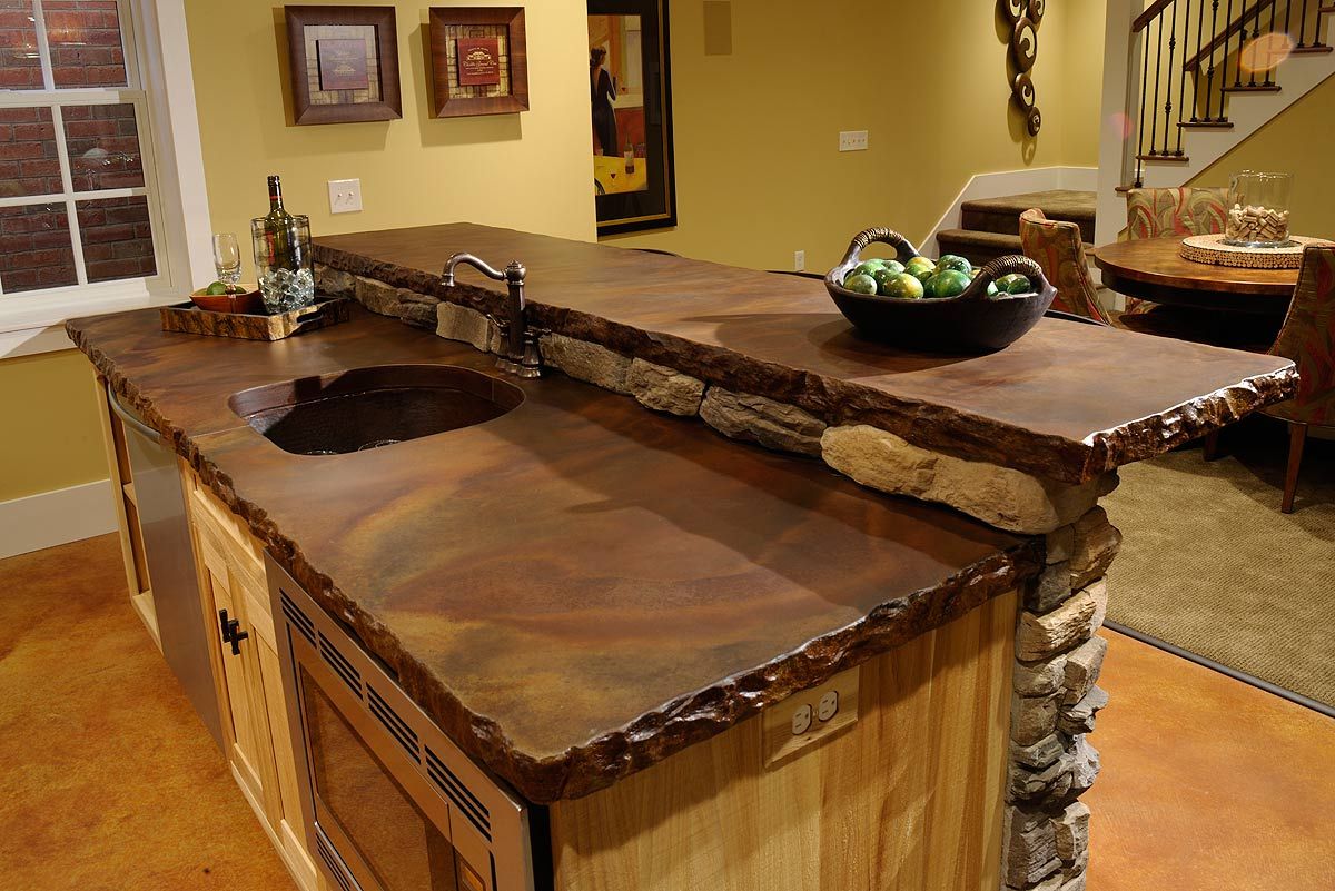 A kitchen island with a rough chiselled stone edge