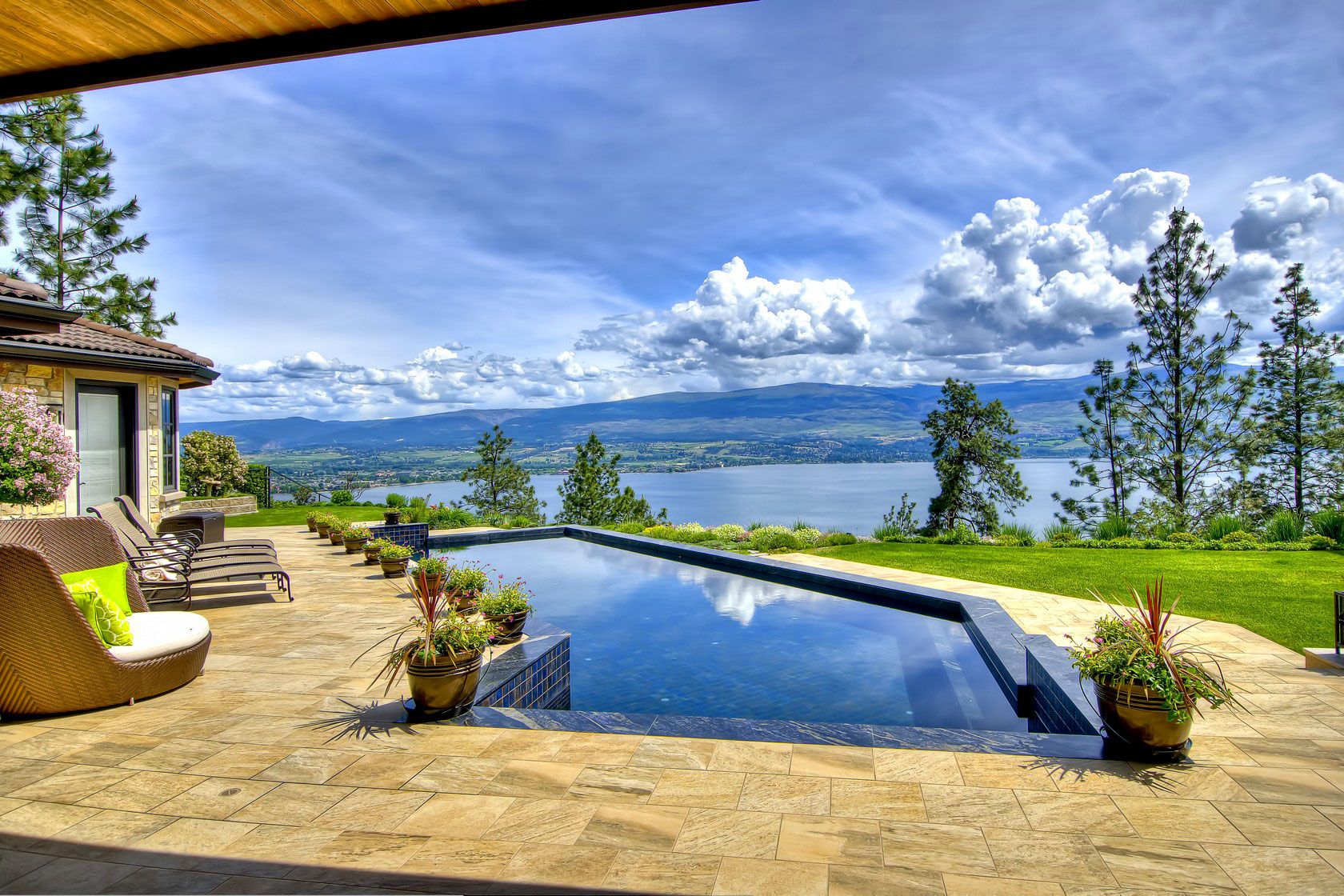 A pool terrace with stone coping, looking out over Okanagan Lake