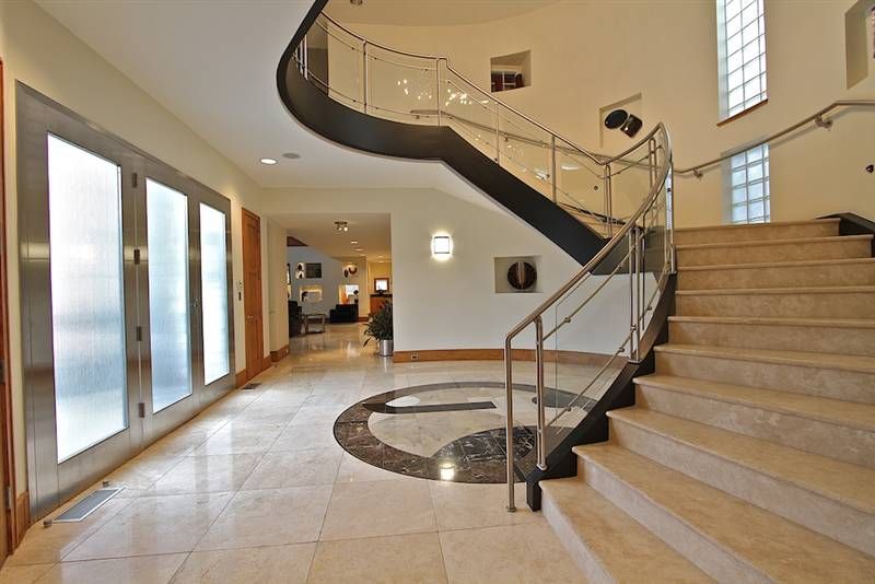 A curved staircase with stone treads and a floor inlay