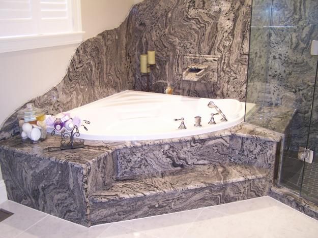 Grey wave granite wrapped around a corner tub deck and its steps